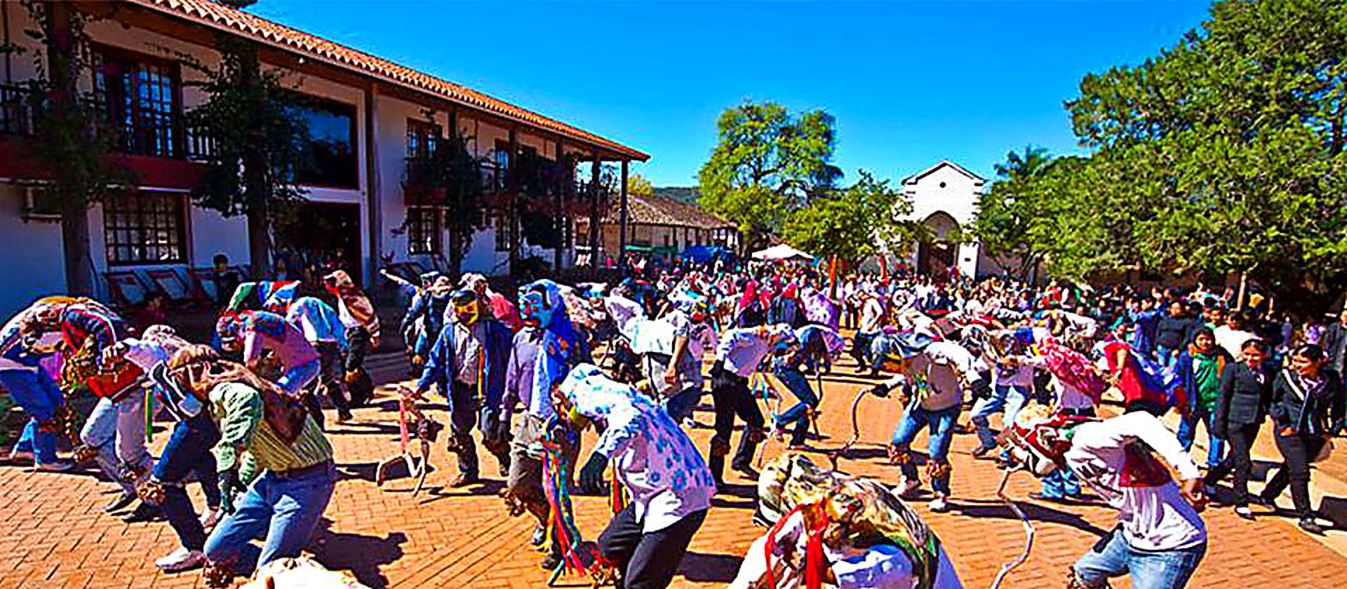 Fiesta patronal en la plaza de Santiago de Chiquitos con danzantes enmascarados