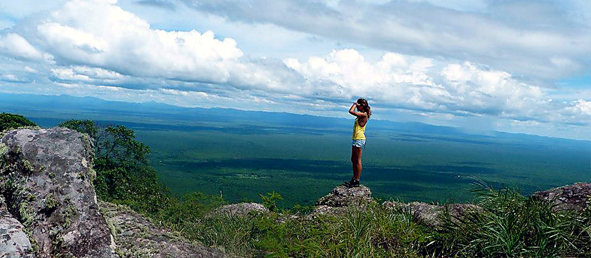 Una persona mirando el Valle de Tucavaca desde el borde de la serranía